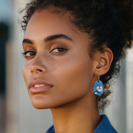 Woman wearing hand-painted birchwood "Butt Nuggets" chicken earring with sterling silver fishhook wire