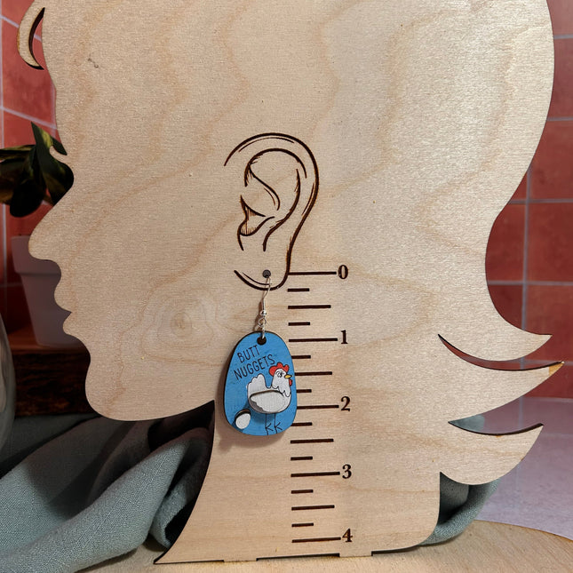 "Butt Nuggets" chicken earring shown on wood earring size chart displaying approximately 2 inch drop length