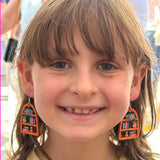 Close-up of a young girl wearing earrings with a blurred background